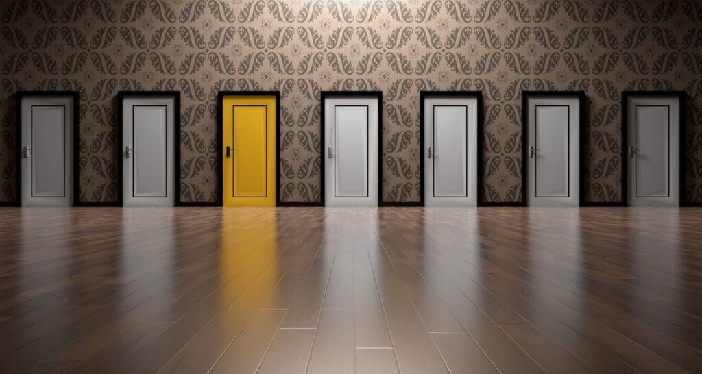Image of hallway with numerous doors and 1 that is unique. (Discover how recruitment agencies streamline hiring, provide access to top talent, and save time for employers. Learn more about the benefits.)